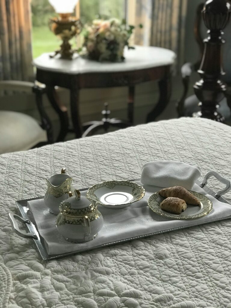 Beautifully arranged breakfast on a luxury tray in an elegant bedroom setting.